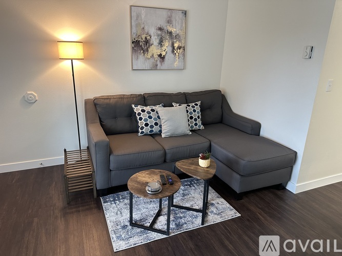 A grey couch with two pillows and a small table in front of it.