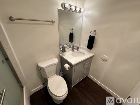 A bathroom with a toilet, sink, and mirror.
