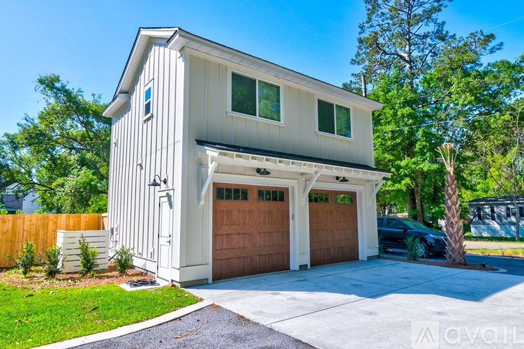 A two-car garage is attached to a white house.