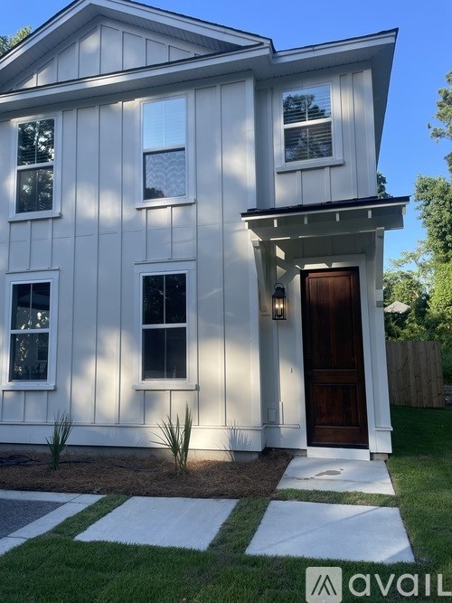 A white house with a brown door and windows.