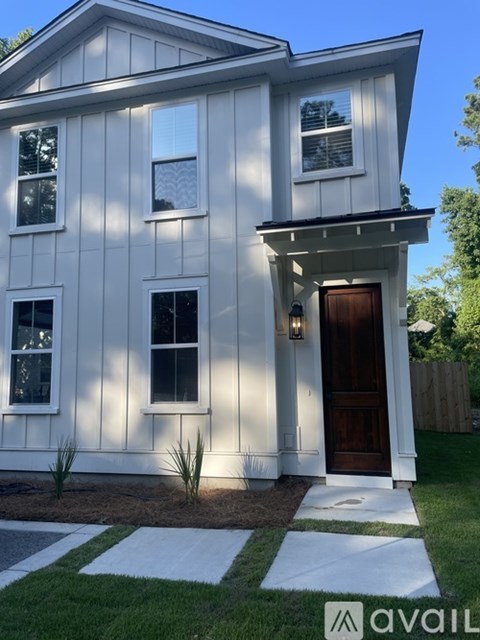 A white house with a brown door and windows.