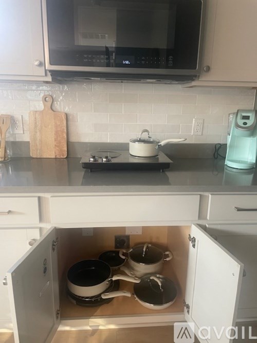 A kitchen with a stove and a pot on it.