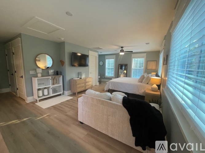 A bedroom with a large bed and a flat screen TV mounted on the wall.