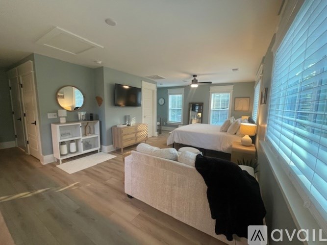 A bedroom with a large bed and a flat screen TV mounted on the wall.