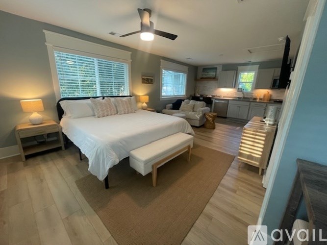 A bedroom with a large bed and a ceiling fan.