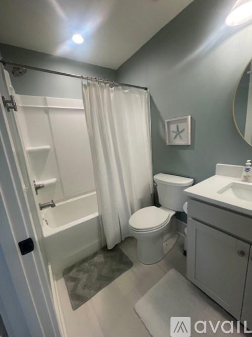 A bathroom with a toilet, sink, and shower.