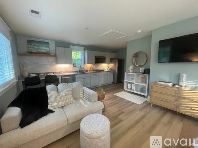 A living room with a white couch and a wooden floor.