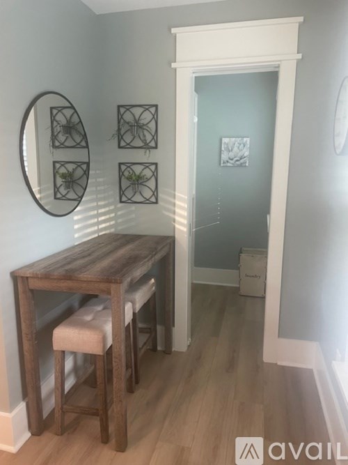 A wooden table with two stools in a room.