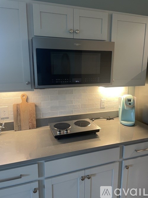 A kitchen with a stove top and a microwave above it.