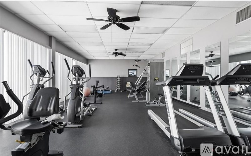 A gym with a variety of equipment including treadmills, stationary bikes, and weight machines.