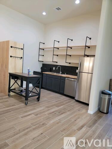 A kitchen area with a table, chairs, and a refrigerator.