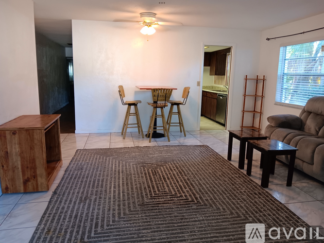 A living room with a brown rug and a wooden cabinet.