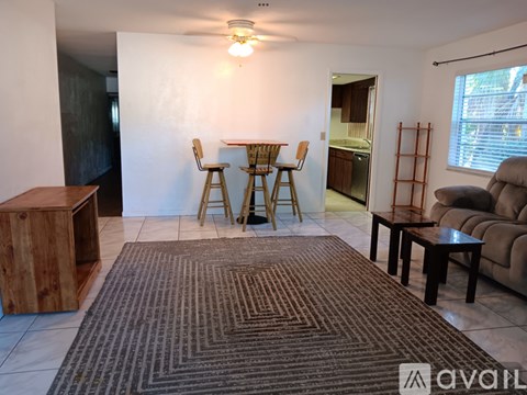A living room with a brown rug and a wooden cabinet.