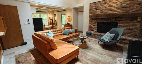 A living room with a brown couch and a fireplace.