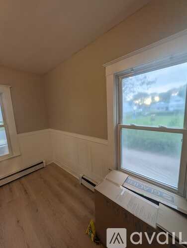 A room with a window and a wooden floor.