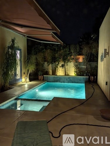 A pool at night with a lit up logo on the side.