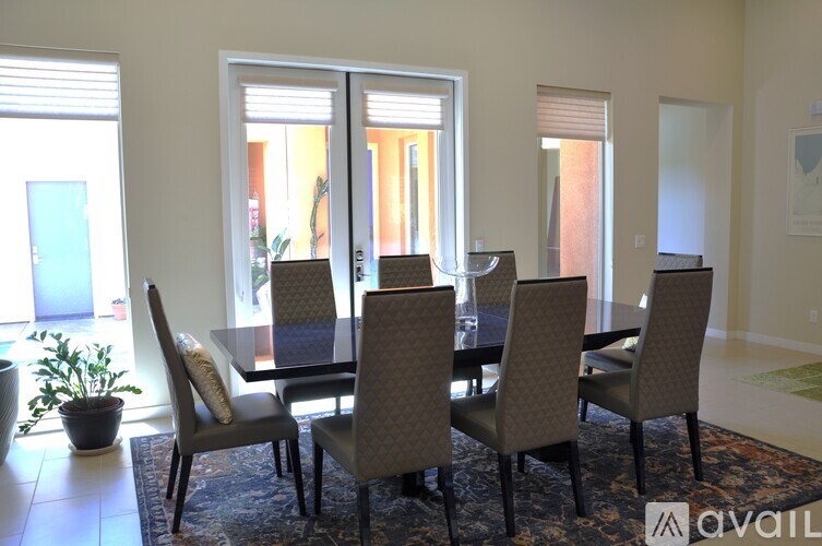 A dining room with a table and chairs.