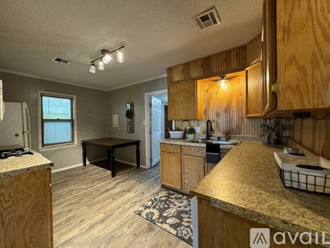 A kitchen with wooden cabinets and a granite countertop.