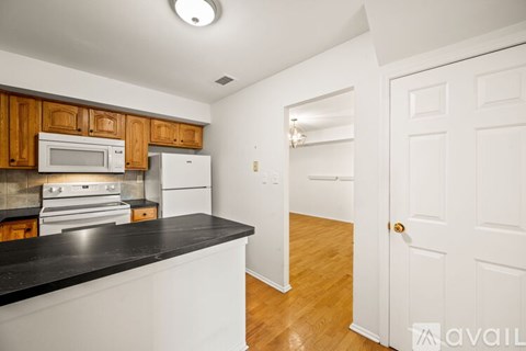 A kitchen with wooden cabinets and a black countertop.