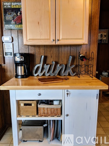 A kitchen counter with a coffee maker and a sign that says "drink".