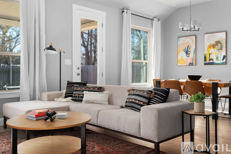 A living room with a grey couch, a coffee table, and a rug.