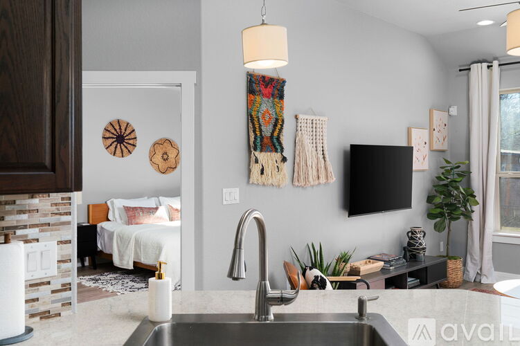 A kitchen with a sink and a wall hanging.