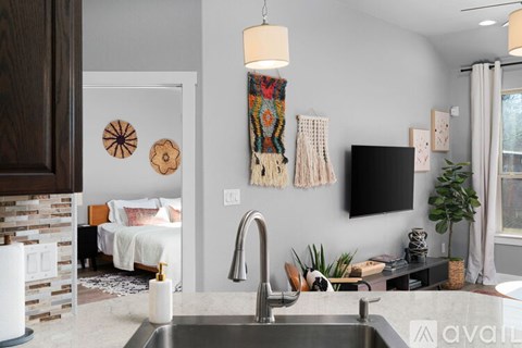 A kitchen with a sink and a wall hanging.