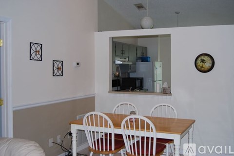 A dining room with a table and chairs.