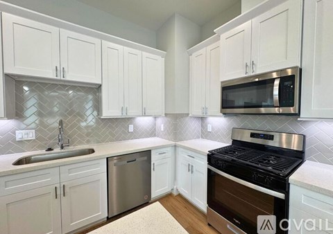 A kitchen with white cabinets and a black stove top oven.