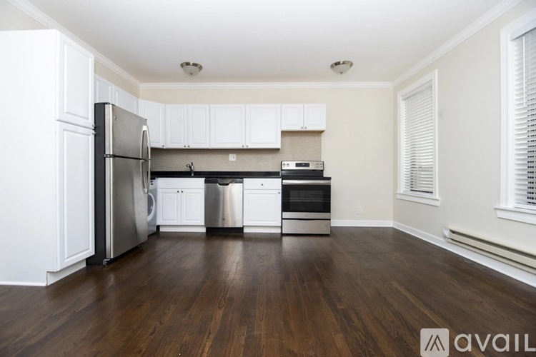 A kitchen with white cabinets and a wooden floor.