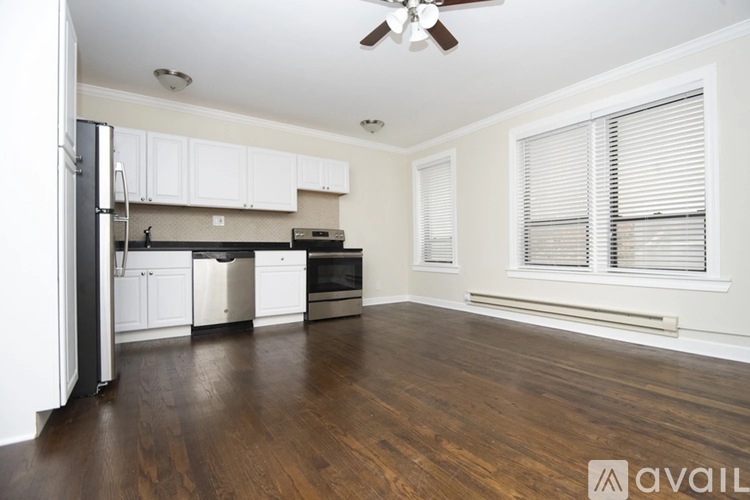 A kitchen with white cabinets and a black fridge.
