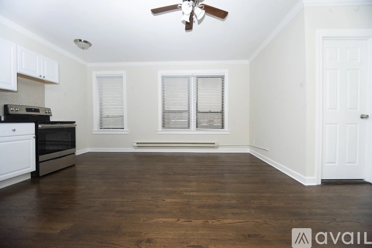 A kitchen with a wooden floor and a ceiling fan.