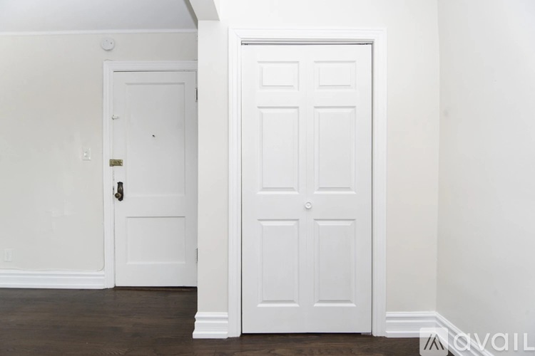 A white door is on the left and a white door with four panels is on the right.