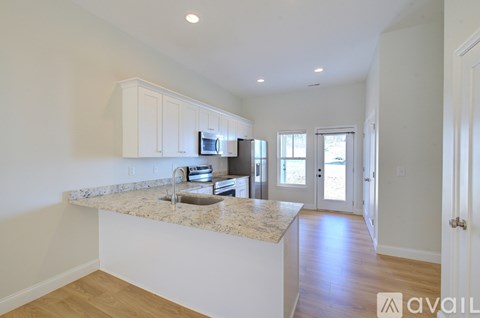 A kitchen with white cabinets and a granite countertop.