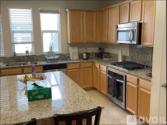A kitchen with granite countertops and wooden cabinets.