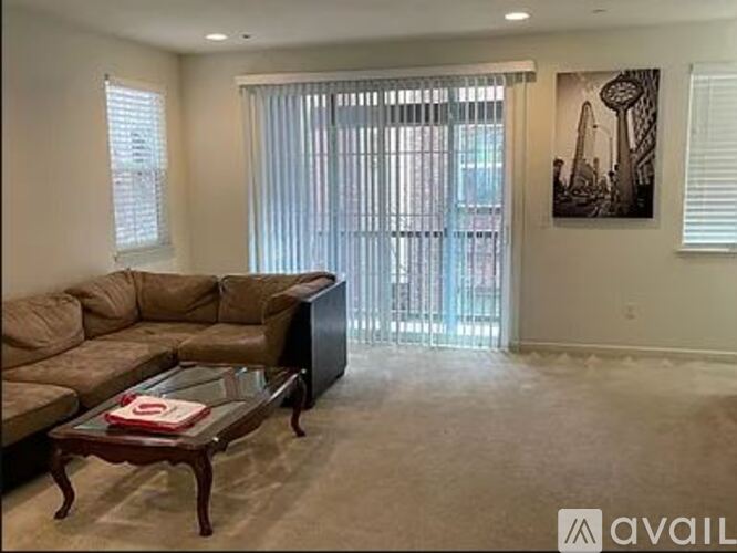A living room with a couch, coffee table, and a painting on the wall.