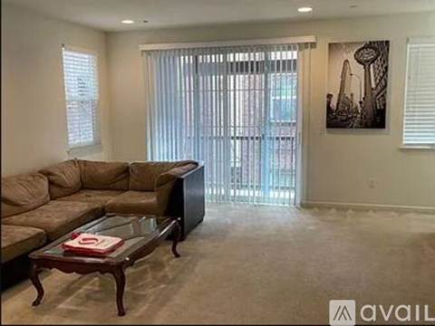 A living room with a couch, coffee table, and a painting on the wall.