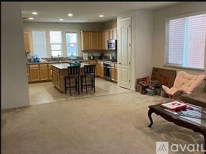 A kitchen with wooden cabinets and a bar area.
