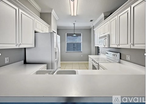 A kitchen with white cabinets and a stainless steel counter.