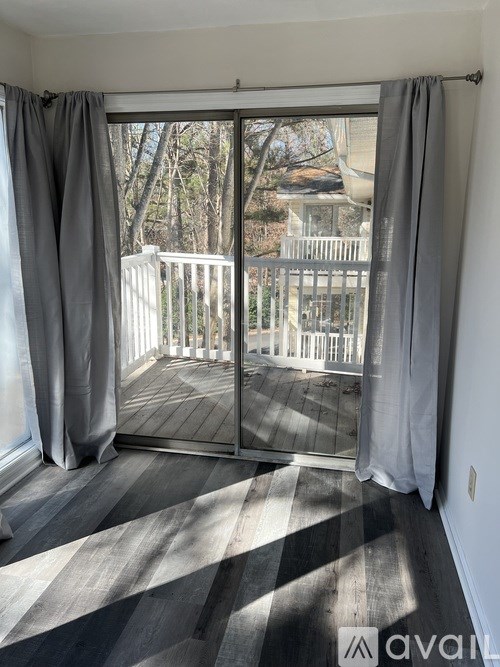 A room with a sliding glass door leading to a balcony.