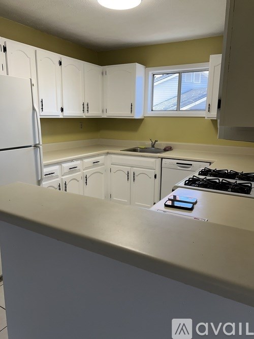 A kitchen with white appliances and cabinets.