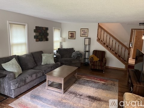 A living room with a grey couch and a wooden coffee table.