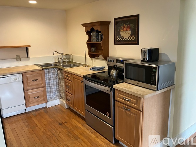 A kitchen with wooden cabinets and a white dishwasher.
