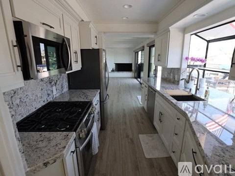A modern kitchen with a black stove top oven and a marble counter top.