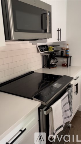 A kitchen with a black counter top and white cabinets.