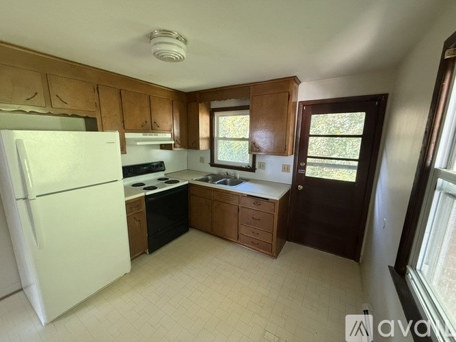 A kitchen with wooden cabinets and a white refrigerator.