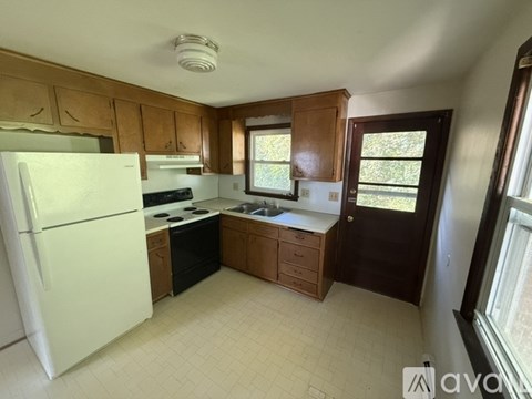 A kitchen with wooden cabinets and a white refrigerator.