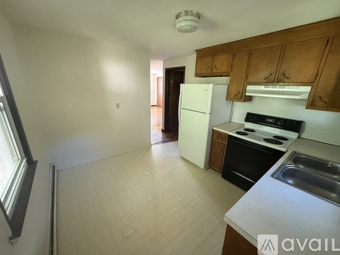 A kitchen with white appliances and wooden cabinets.