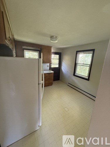 A kitchen with a white refrigerator and a window.