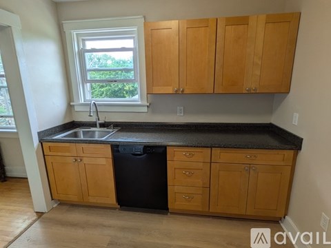 A kitchen with wooden cabinets and a black countertop.